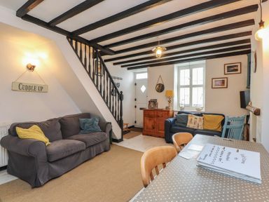 A living room with a sofa and table at Menuchah in Criccieth