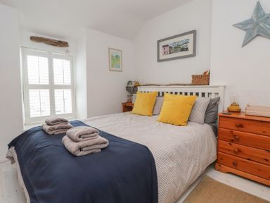 A bedroom with a bed and dresser at Menuchah in Criccieth