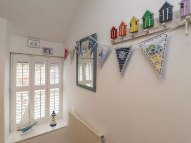 A hallway with a window and decorative items at Menuchah in Criccieth