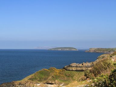 A coastal scene with cliffs and an island in the sea at The Stables in Penmon near Beaumaris