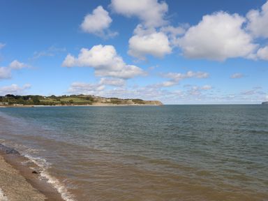 A coastline with water grassy hills and clouds in the sky at The Stables in Penmon near Beaumaris
