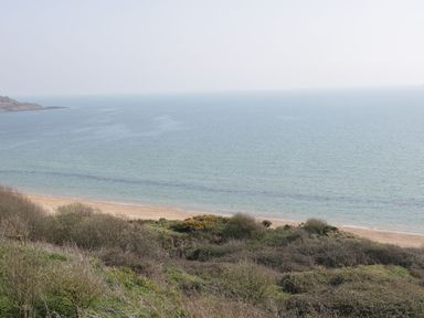A coastal view with sandy beach shrubs and the sea at Emminster in Nottington near Weymouth