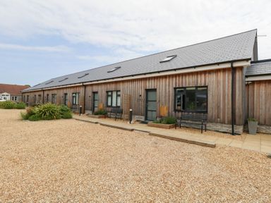 A wooden building with benches and gravel area at Durbyfield Nottington near Weymouth