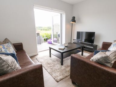 A living room with a coffee table and television at Durbyfield Nottington near Weymouth