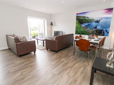 A living room with sofas and a dining area at Durbyfield in Nottington near Weymouth