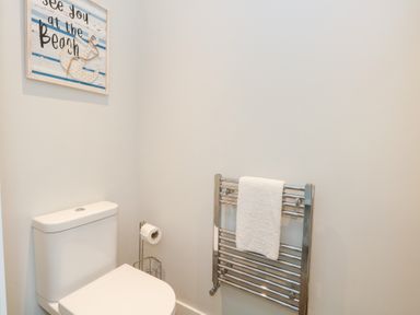 A bathroom with a toilet and towel rack at Durbyfield in Nottington near Weymouth