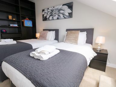A bedroom with two beds and a bookshelf at Durbyfield in Nottington near Weymouth
