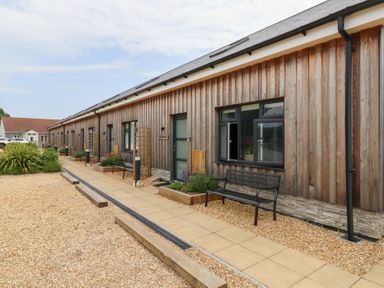 An outdoor area with a wooden building and benches at Durbyfield Nottington near Weymouth