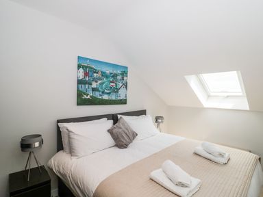 A bedroom with a double bed a painting above the bed and a skylight window at Lulstead in Nottington near Weymouth
