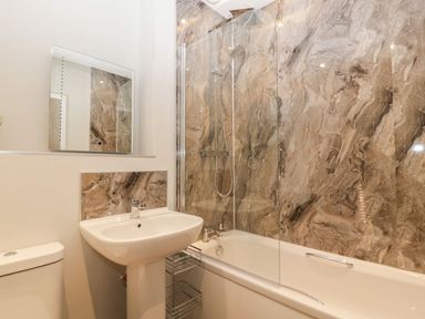 A bathroom with a bathtub shower combination sink and toilet at Lulstead in Nottington near Weymouth