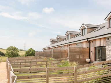 A row of connected houses with wooden fences and small gardens at Lulstead in Nottington near Weymouth