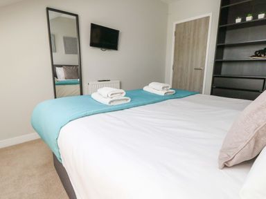 A bedroom with a double bed and a mirror at Overcombe Mill in Nottington near Weymouth