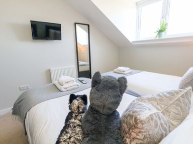 A bedroom with two beds and a TV at Overcombe Mill Nottington near Weymouth