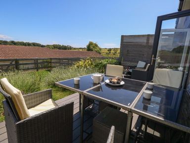An outdoor dining area with a table and chairs at Overcombe Mill in Nottington near Weymouth