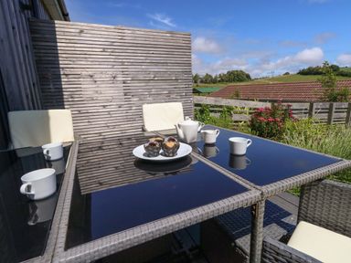 An outdoor seating area with a table and chairs at Overcombe Mill Nottington near Weymouth