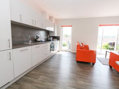 A kitchen with appliances and seating area at Corvesgate Nottington near Weymouth