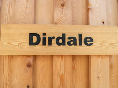 A wooden sign with the word Dirdale on a wooden wall at Dirdale in Weymouth