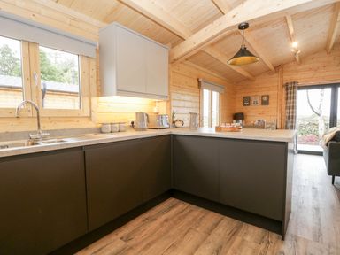 A kitchen area with dark lower cabinets and a countertop with appliances at Howgills Retreat in Gatebeck near Kirkby Lonsdale