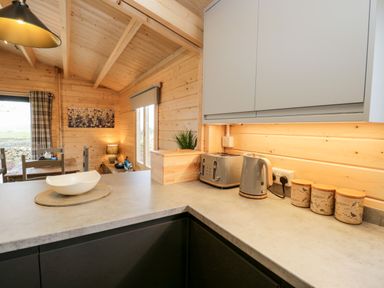 A kitchen countertop with a toaster kettle bread box and canisters in a wooden room at Howgill Lodge in Gatebeck near Kirkby Lonsdale