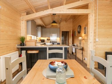 A kitchen and dining area with wooden walls and ceiling at Howgill Lodge in Gatebeck near Kirkby Lonsdale