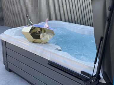 A hot tub with champagne and glasses at Ninky Nonk in Bishop Sutton