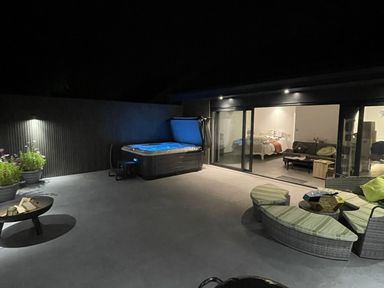 A patio with a hot tub and outdoor seating at Ninky Nonk in Bishop Sutton