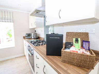 A kitchen counter with a gas stove a microwave kettle and a basket of snacks at Rashierigg in Catterick North Yorkshire