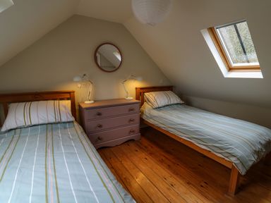 A bedroom with two single beds and a chest of drawers between them at Pen y Mynydd in Newport Pembrokeshire