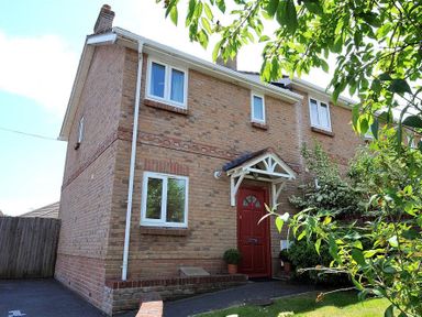 A brick house with a red front door and white windows at 1 Coppers Knapp Lyme Regis