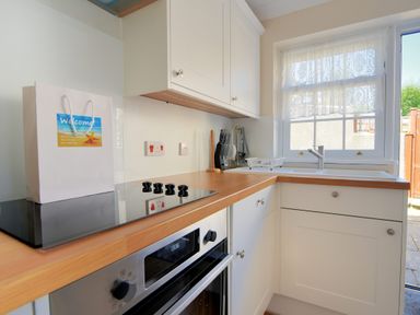 A kitchen with a stovetop oven sink and knife set at Blacksmiths Cottage Lyme Regis