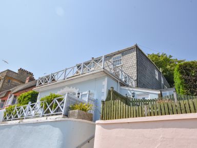 Exterior view of a two-story house with white railings and fences under a clear sky at 3 Argyle House in Lyme Regis