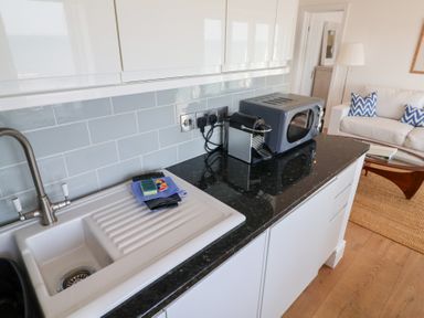 A kitchen with a sink and microwave at Seagull in Lyme Regis