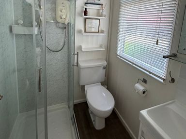 A bathroom with a shower and toilet at 8 Bowling Green Chalets in Lyme Regis