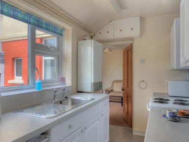 A kitchen with a sink and stove with a cup and plate on the counter at 23 Lym Close Lyme Regis