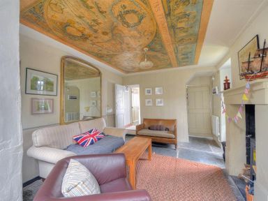 A living room with sofas a wooden coffee table a large mirror and a decorated ceiling at 10 Cobb Terrace Lyme Regis