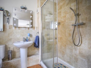A bathroom with a shower cubicle sink toilet and mirror at Jurassic Sea View in Lyme Regis
