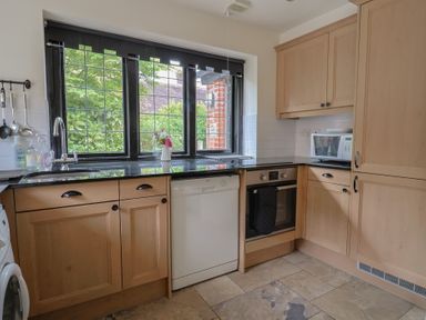 A kitchen with cabinets, sink, dishwasher, oven, and microwave at Yard Cottage in Rousdon