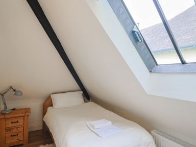 A bedroom with a bed and lamp at Yard Cottage in Rousdon