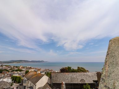 A coastal town with rooftops and sea in the background at The Penthouse in Lyme Regis