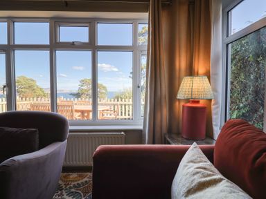 A living room with a view and a lamp at Westhaven in Lyme Regis