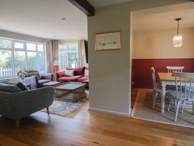 A living room with a sofa and coffee table adjacent to a dining area at Westhaven in Lyme Regis
