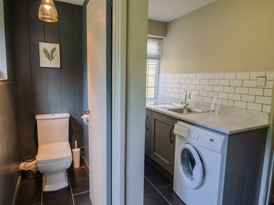 A laundry room with a washer and sink at Westhaven in Lyme Regis