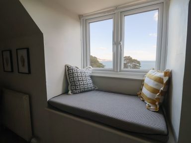 A snug area with a window seat and pillows at Westhaven in Lyme Regis