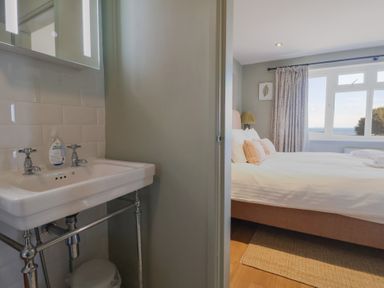 A bedroom with a sink and mirror at Westhaven in Lyme Regis