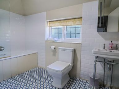 A bathroom with a bathtub, toilet, and sink at Westhaven Lyme Regis