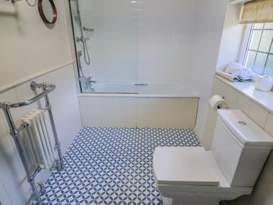 A bathroom with a bathtub and toilet at Westhaven in Lyme Regis