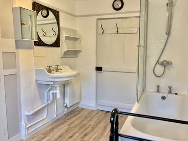 A bathroom with a sink mirror and bathtub with shower at 24 Mill Green in Lyme Regis
