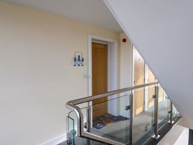 A hallway with wooden doors and a welcome sign on the wall at 2 Driftwood in West Bay