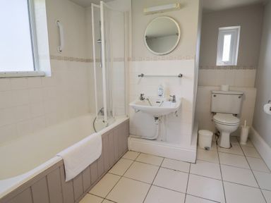A bathroom with a bathtub shower sink and toilet at Tillicum in Charmouth