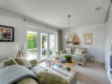 A living room with plaid sofas and a coffee table near glass patio doors at Highpoint Lodge in Lyme Regis